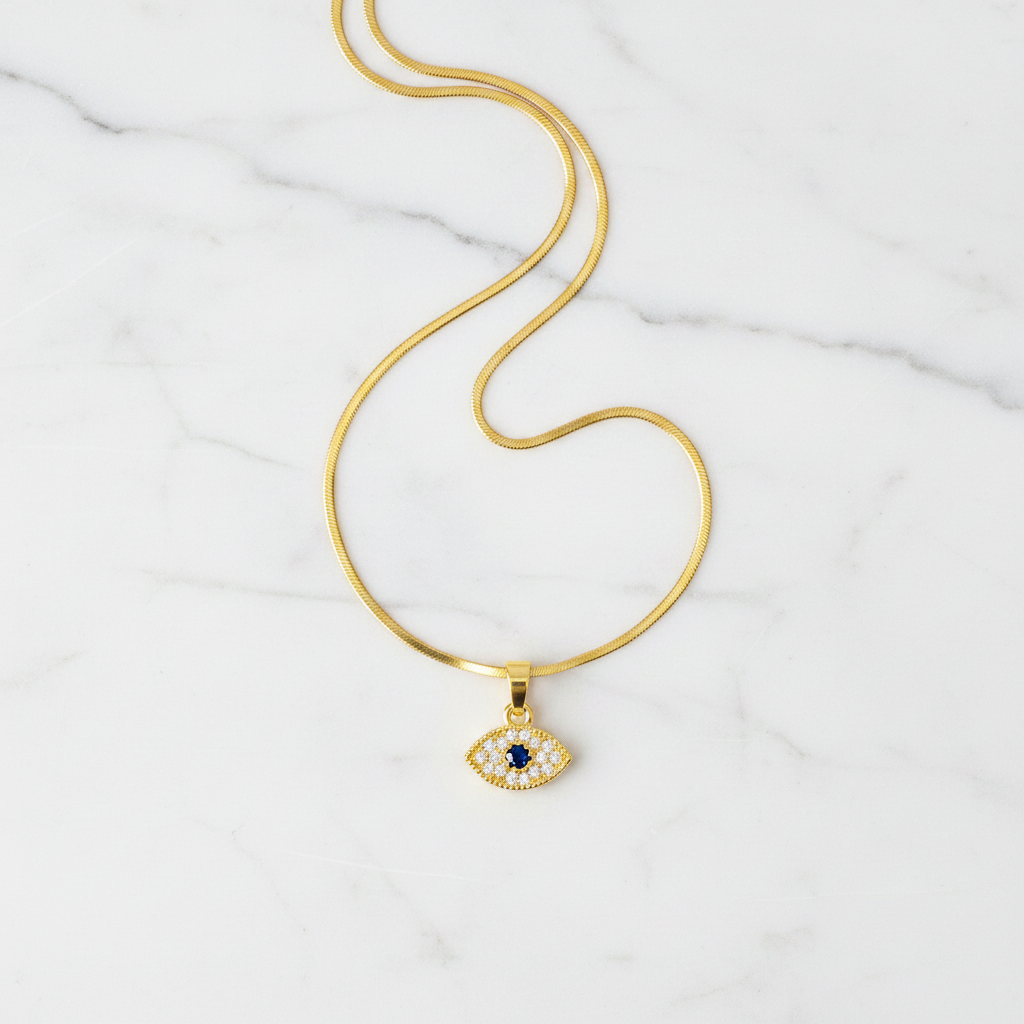 Evil Eye Pendant Necklace - flat lay on white marble