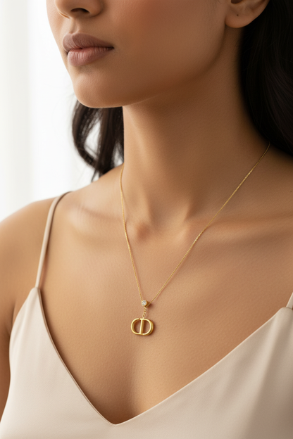 Double Oval Signature Necklace – model wearing gold logo pendant necklace, close-up