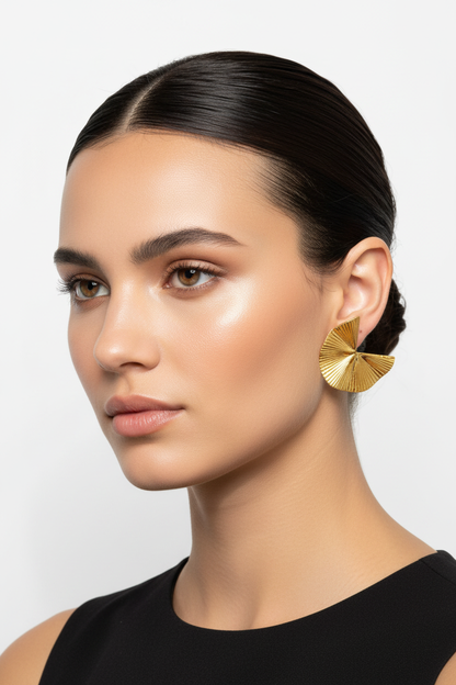 Model wearing gold fan earrings